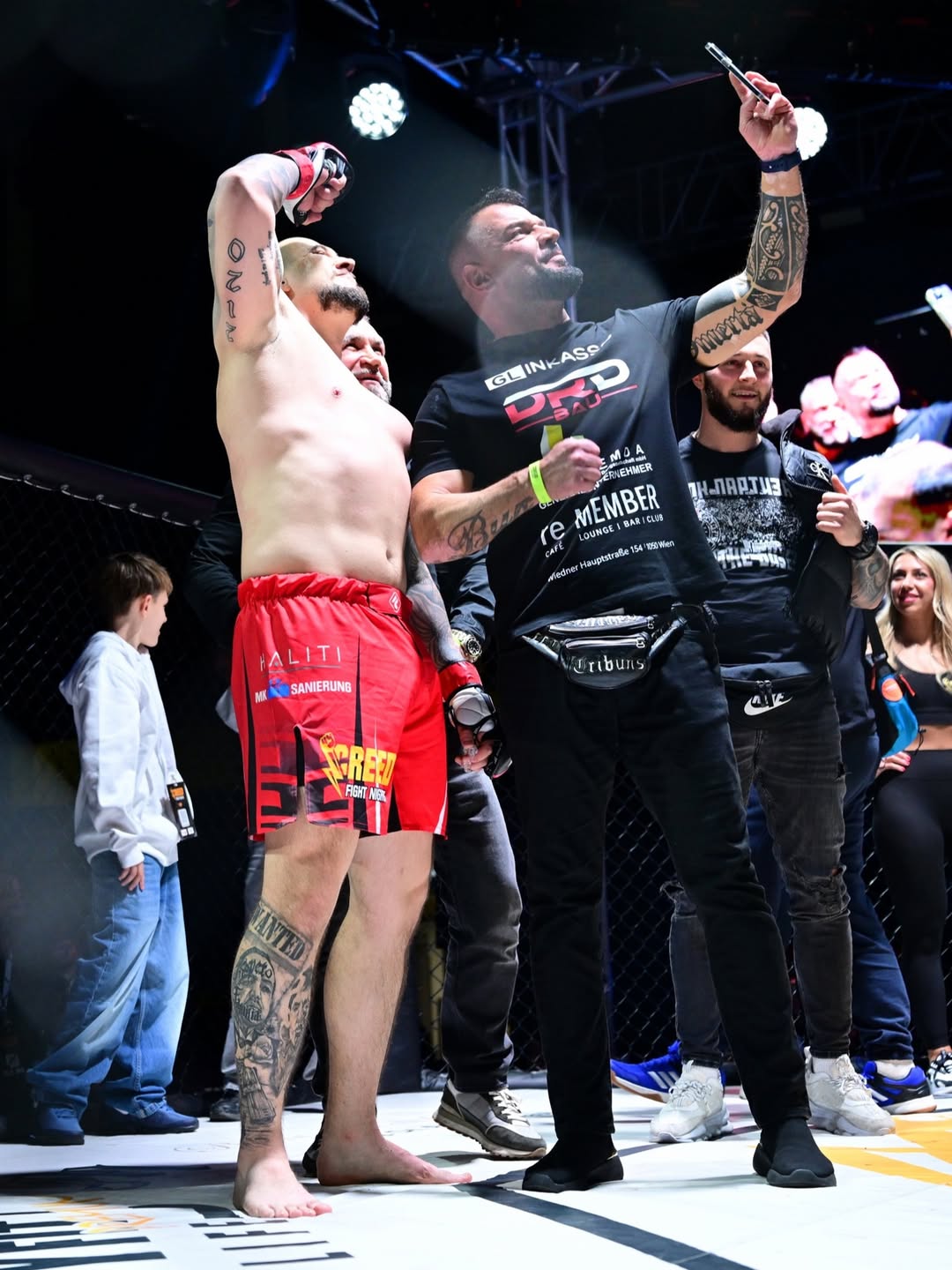 Sieger-Pose: Arm wird vom Coach im Cage gehoben